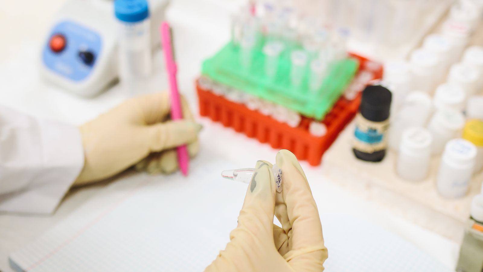 Laboratory scientist examining samples and recording quality-control observations