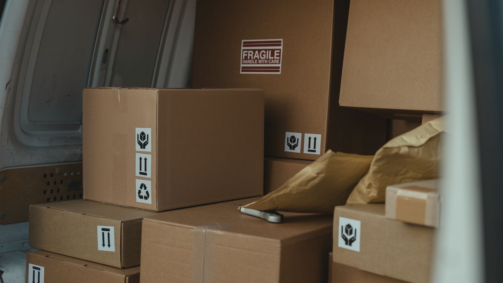 Sealed cartons arranged inside a delivery vehicle for controlled logistics handling