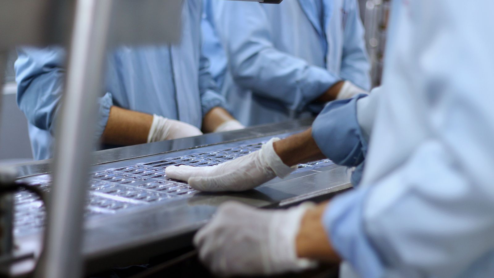 Protected workers monitoring medicine packaging on a controlled production line
